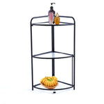 Black metal corner shelf with three tiers, holding a bottle, a bowl of bananas, and a container. | Artisansa SA