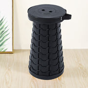 Black retractable telescopic foot stool KJ-01 folding stool on wooden floor with light-coloured wall background | Artisansa SA