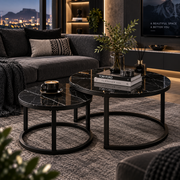 Black marble-look nesting coffee tables with black frames in a dark modern lounge