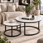 White marble-look nesting coffee tables with black frames styled in a neutral lounge