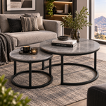 Grey stone-look nesting coffee tables with black frames in a modern apartment lounge