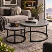 Grey stone-look nesting coffee tables with black frames in a modern apartment lounge