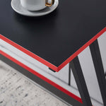 Close-up of L-Shaped Desk with Monitor Shelf OD-59 featuring a sleek black surface and vibrant red trim with a coffee cup.