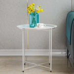 Steel side table set with flowers and cup on a modern interior backdrop.