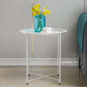 Steel side table set with flowers and cup on a modern interior backdrop.