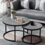 Black and Grey round nesting coffee table set beside a dark grey sofa