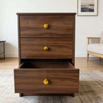 Modern 3-Drawer Nightstand with gold handles, showcasing open drawer in stylish interior setting.