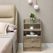 White Bedside Table with Drawers set next to a bed, featuring two drawers and an open shelf for decor.