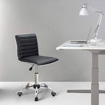 Adjustable bar stool set in ergonomic black PU leather beside a modern desk with lamp and laptop.