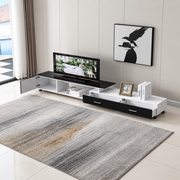 Fully extended black and white TV stand with open cabinet and two storage drawers in a lounge