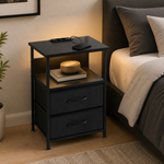 Black bedside table with charging station, LED light and two fabric drawers styled beside a modern bed.