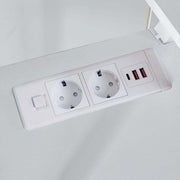 Close-up of built-in AC power outlets and USB charging ports on desktop