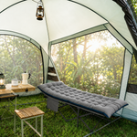 Heavy-duty folding camping cot with mattress set up in nature setting