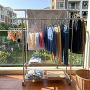 Double Rail Clothes Rack with Shoe Shelf featuring hanging garments and organized space on a balcony.