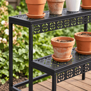 Close-up of decorative perforated metal shelves and flower pots on the plant stand