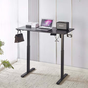 Electric Standing Desk in black with laptop and speaker, showcasing adjustable height for ergonomic comfort.