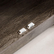 Close-up of farmhouse sideboard storage cabinet hardware connections on a rustic brown finish.