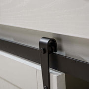 Close-up of farmhouse wine bar cabinet sliding door hardware, showcasing metal track and rustic white wood.