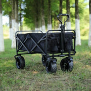 Black collapsible outdoor cart with brakes ready for use on park grass