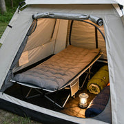 Cozy folding camping cot with mattress used inside a large family tent