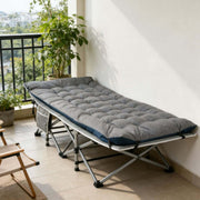 Portable folding camping cot with mattress used for relaxing on home balcony
