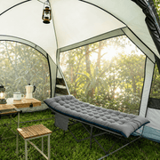 Heavy-duty folding camping cot with mattress set up in nature setting