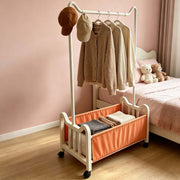 Steel Clothing Rack with shelves and wheels holding clothes and hats in a stylish bedroom.