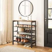 Industrial shoe rack beneath a round entryway mirror with shoes on mesh shelves and decorations on top