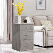 Modern 3-Drawer Nightstand with gold handles beside a sofa, featuring a vase of flowers and a clock.