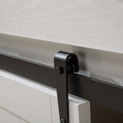 Close-up of farmhouse wine bar cabinet sliding door hardware, showcasing metal track and rustic white wood.