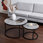 Black and Grey nesting coffee tables with décor beside a grey lounge sofa