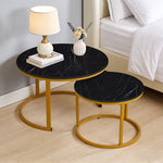 Black marble-look nesting side tables with gold frames styled beside a bed