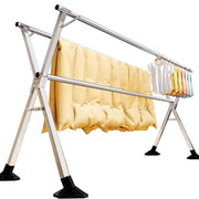 Foldable Clothes Rail – Stainless Steel X-Frame with clothing hanging and quilts drying.