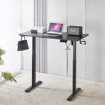 Electric Standing Desk in black with laptop and speaker, showcasing adjustable height for ergonomic comfort.