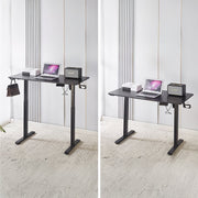 Electric Standing Desk in black, adjustable height with laptop and speaker, ideal for ergonomic workspace.