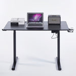 Electric Standing Desk black adjustable with laptop, books, and speaker, designed for ergonomic comfort.