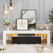White and black TV unit styled with artwork and warm LED lighting in a bright lounge