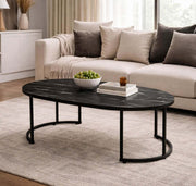 Oval Black Marble Coffee Table with decorative bowl and books in a stylish living room setting