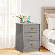 Modern 3-Drawer Nightstand featuring gold handles, styled beside a bed in a bright room.