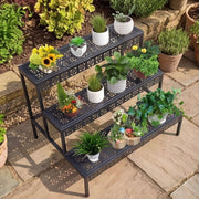 Top-angle view of black 3-tier plant stand with herbs, flowers and decorative pots