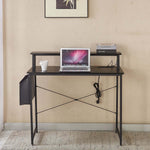 Modern computer desk with power outlets, laptop on top, coffee cup, and books in a home office setting.