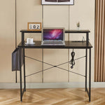 Modern computer desk featuring power outlets, sleek design, and workspace setup with a laptop and coffee.