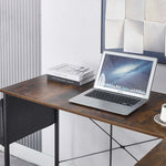 Reversible L-Shaped Computer Desk with a laptop, books, and a coffee cup in a stylish home office setting.