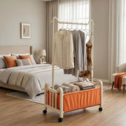Steel Clothing Rack with Shelves & Wheels in a cozy bedroom displaying hanging clothes and neatly folded towels.