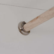 Metal bracket holding a wooden rod against a white ceiling surface, ideal for wardrobe organization.